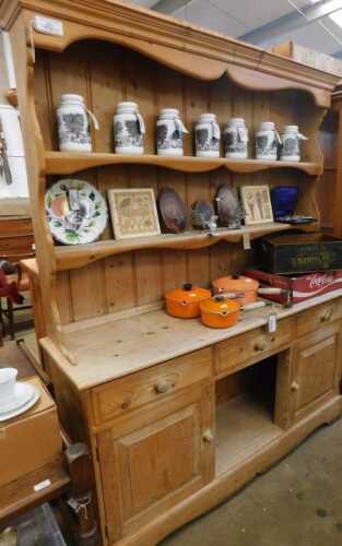 V - An early 20thC pine kitchen dresser, the upper section with two Delft racks, raised above three...