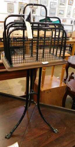 V - An early 20thC oak and metal freestanding magazine rack, with shaped centre, on triple sabre...