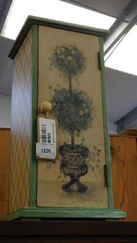 V - A table cabinet, stencilled with lattice and tree decoration in green and cream, 19cm high, 20cm...