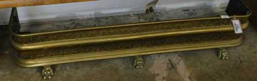 V - An early 20thC brass D-end fender, of part-pierced form, on lion's paw feet, 26cm high, 117cm...