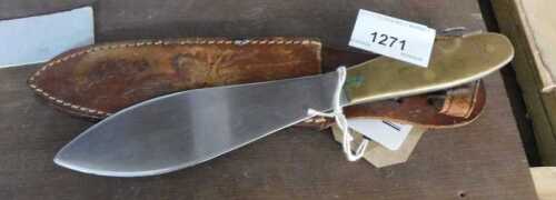V - A shaped knife, with a wide plain blade and brass handle with leather scabbard, 22cm long. NB....