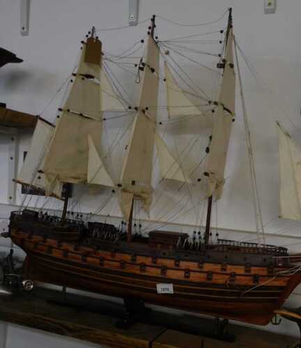 V - A late 20thC wooden model of a galleon, with realistic decking and rigging, on a plinth base,...