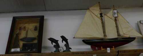 V - A 20thC model of a boat, with realistic deck and masts, partially painted in red and black, on a...
