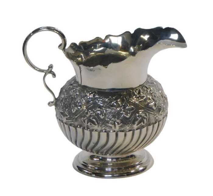 A Victorian silver milk jug, of semi fluted form, decorated with a band of embossed ivy leaves...