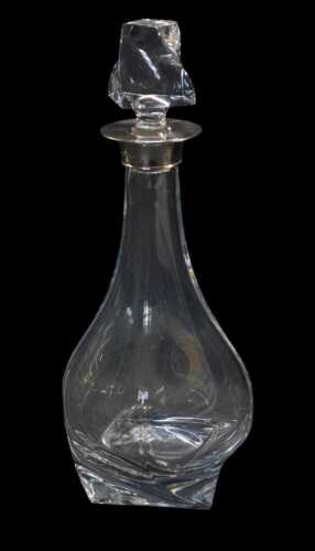 An Elizabeth II cut glass decanter with a silver mount, of bottle shaped twisted form, with...