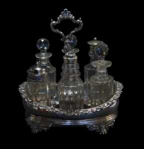 A George IV and later silver cruet stand, of oval form, the border decorated with scrolls and...