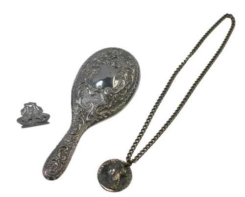 A Victorian silver backed hand mirror, embossed with flower head and scrolling motifs, with a...