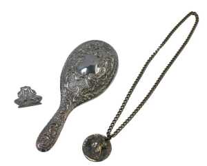 A Victorian silver backed hand mirror, embossed with flower head and scrolling motifs, with a...
