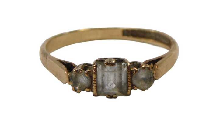 A 9ct gold dress ring, set with three imitation diamonds, one square cut and two round brilliant...