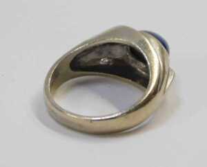 A sapphire and diamond dress ring, the centre set with a star set sapphire, 9.6mm x 5.2mm x... - 2