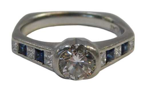 A sapphire and diamond dress ring, with a central round brilliant cut diamond, approx 0.76ct, in...