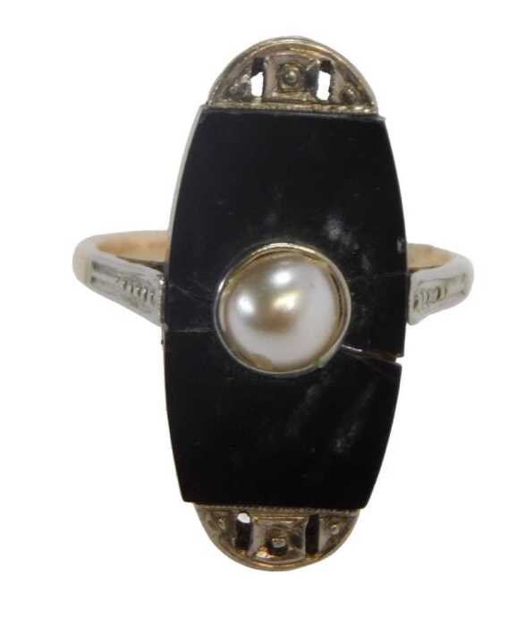 An Art Deco style dress ring, set with a panel of jet and centred by seed pearl, with platinum...