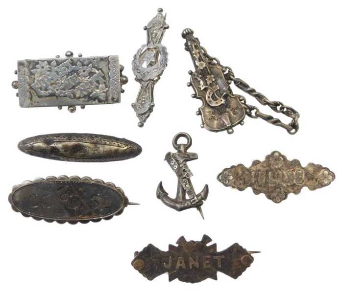 Eight silver brooches, to include a sweetheart brooch, named brooches for Nelly and Janet, and a...
