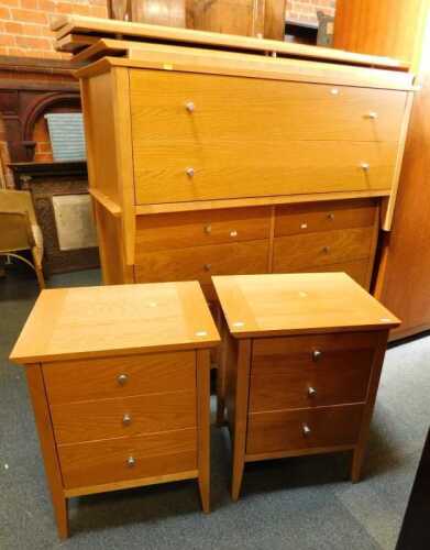 A contemporary light oak finished bedroom suite, comprising two three-drawer bedside chests, a...