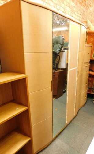 An Alstons Synergy bedroom suite, comprising a four-door wardrobe with a mirrored centre section,...