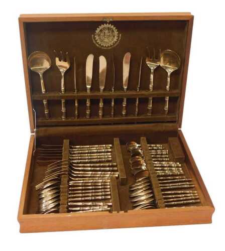 A Thai brass canteen of cutlery, for six place settings, each with a simulated bamboo handle,...