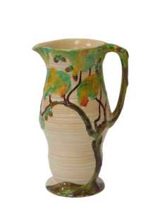 A Carltonware relief moulded jug, decorated with an oak tree with acorns, against a buff ground,...