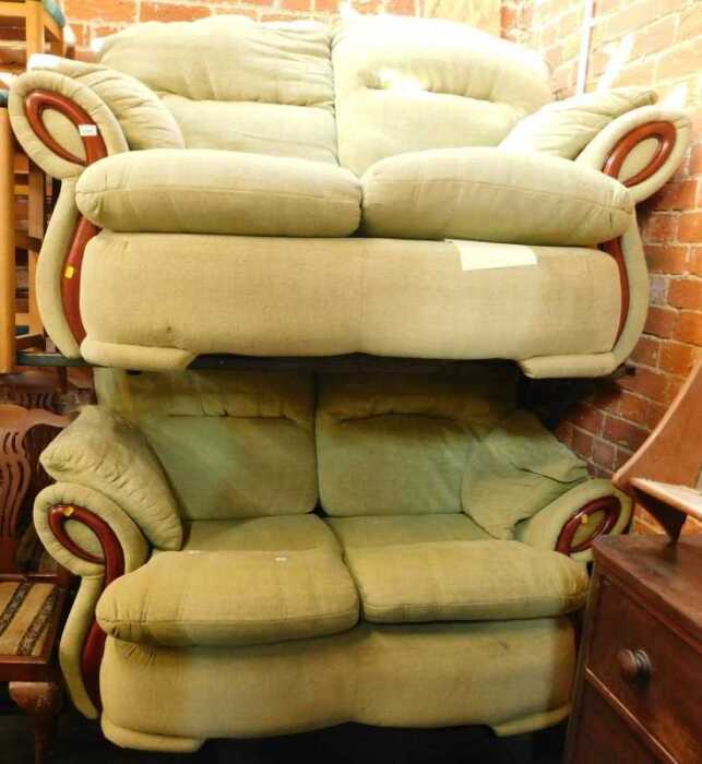 A pair of two seater modern sofas, upholstered in green fabric.