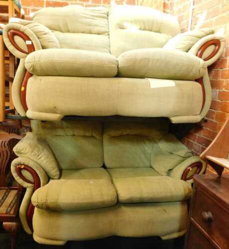 A pair of two seater modern sofas, upholstered in green fabric.