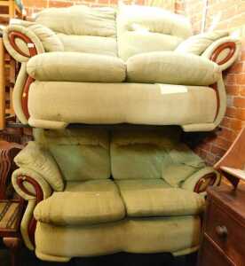 A pair of two seater modern sofas, upholstered in green fabric.