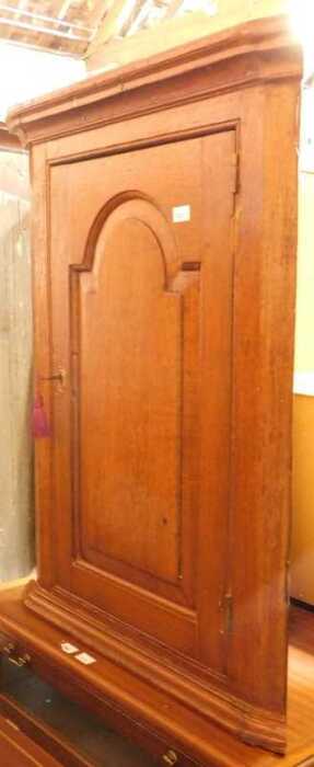 A George III oak hanging corner cabinet, the top with a moulded edge above a hanging door...