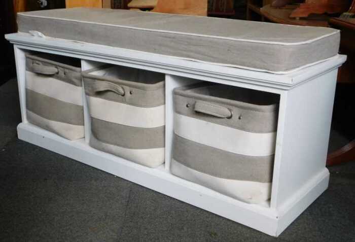 A contemporary white finished bench seat, with three bags to three enclosures, raised on plinth...