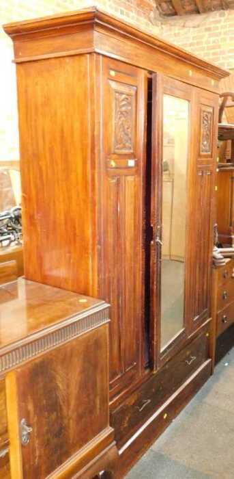 A late 19th/early 20thC wardrobe, with cornice over central door with bevelled mirror, over...