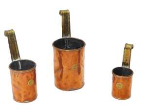 A set of three Victorian graduated copper and brass cream ladles, two pint, one pint, and half...
