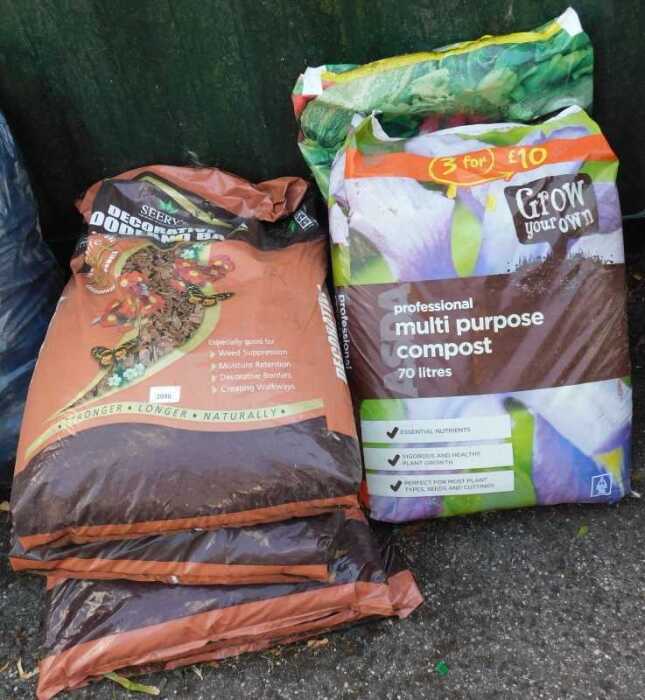 Four bags of decorative woodland bark, together with a bag of Professional Multipurpose compost,...