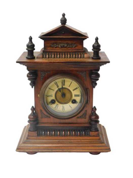 A late 19thC oak cased mantel clock, the circular dial bearing an enamelled Roman numeric...