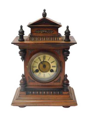 A late 19thC oak cased mantel clock, the circular dial bearing an enamelled Roman numeric...
