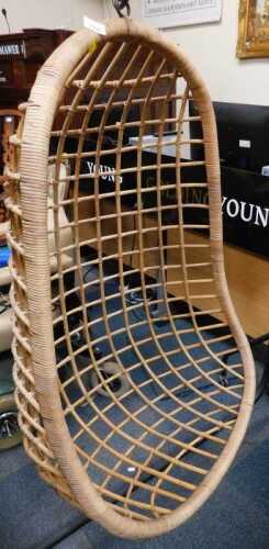 A wicker egg shaped chair, lacking stand.