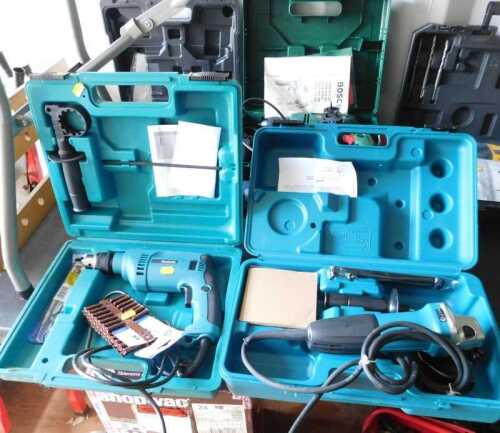 A Makita electric angle grinder, and a hammer drill, boxed. (2)