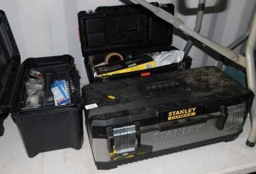 Three Stanley plastic toolboxes, each containing handtools.