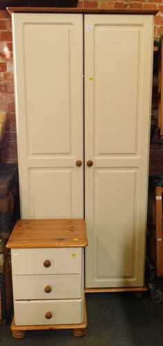 A contemporary two-door wardrobe raised on bun feet, 186cm high, 84cm wide, 60cm deep, and a...