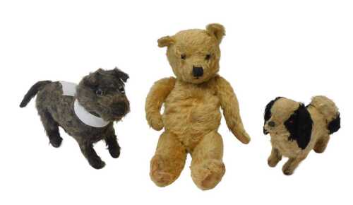 A group of early 20thC straw filled soft toys, comprising a blonde jointed Teddy bear, 39cm high,...