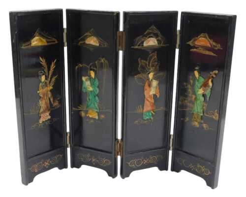 An early 20thC Oriental black lacquer four-fold screen, each section carved with a depiction of...