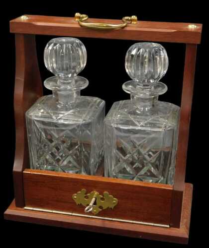 A late 20thC wooden cased twin-division Tantalus, with a brass swing handle, containing two...