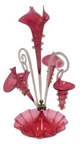 A Victorian cranberry glass epergne, the central trumpet-shaped vase flanked by twisted...