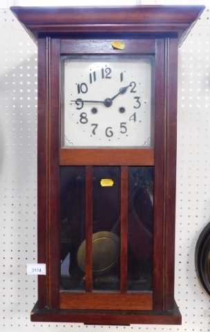 An oak cased wall clock, the square enamel dial bearing Arabic numerals, with an eight day...