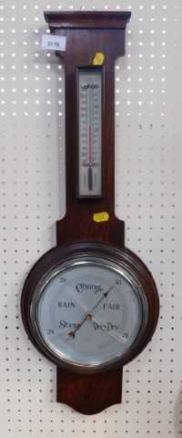 An oak cased drop dial barometer, with silvered dial and thermometer, 65cm high.
