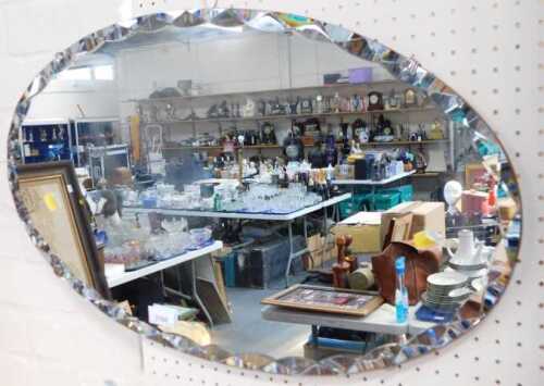 An oval mirror, circa 1950s.