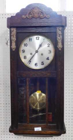 An oak cased wall clock, the circular silvered dial bearing Arabic numerals, with an eight day...