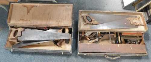 Two large wooden toolboxes containing hand tools, including saws, planes, etc.