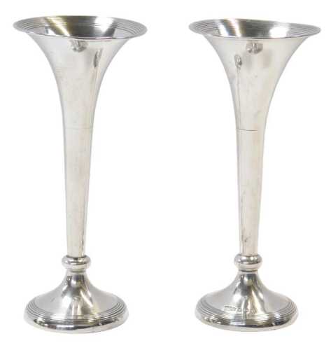 A pair of Edward VII loaded silver posy trumpet vases, with inner multiple banded decoration,...