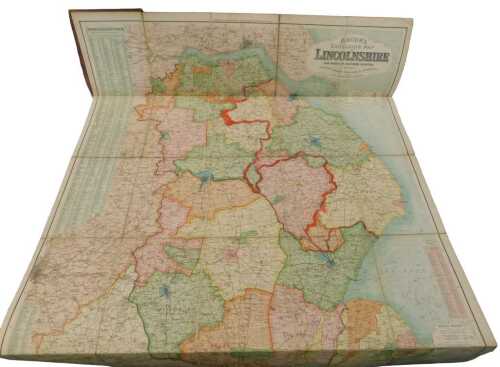A Bacon's Excelsio map of Lincolnshire, linen-backed in purple gilt stencil boards, with John T...