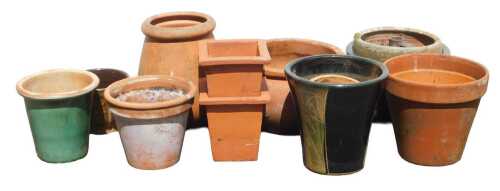 A group of terracotta and stoneware plant pots, each of differing size and design, some green...