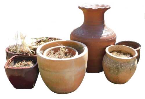 A group of terracotta plant pots, together with a planter of baluster form, with incised...