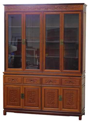 A 20thC Chinese hardwood display cabinet, the outswept pediment over a frieze carved with birds...