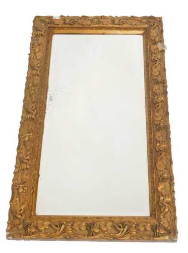 A late 19thC Art Nouveau giltwood and gesso wall mirror, decorated with repeating flowers and...